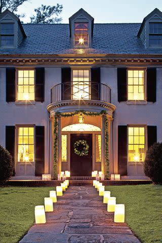 Photo: Laurey W. Glenn; Styling: Caroline Cunningham Who says you need a porch to make your yard merry? We love simple and easy luminaries lighting the way to this stately house.