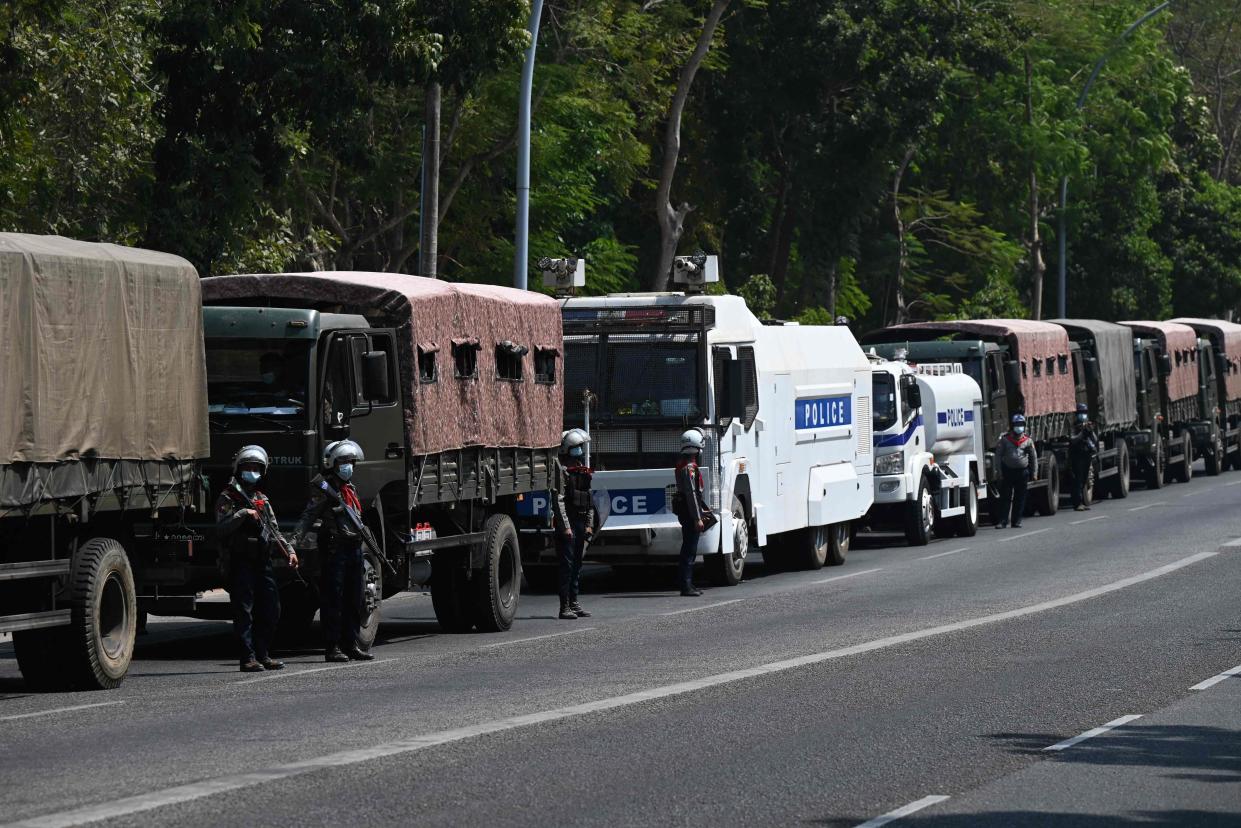 <p>Police and military vehicles are pictured outside the Yangon University compound during a protest</p> (AFP via Getty Images)