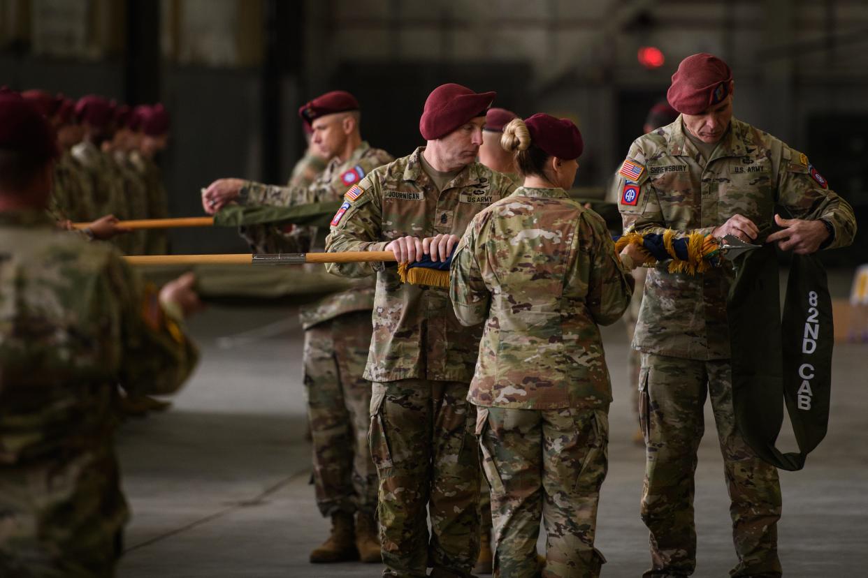 Command Sgt. Maj. James Journigan, left to right, Col. Kirsten Schwenn and Chief Warrant 5 Timothy Shrewsbury case the 82nd Combat Aviation Brigade colors during a casing ceremony on Friday, Dec. 1, 2023, ahead of its deployment to the Middle East.