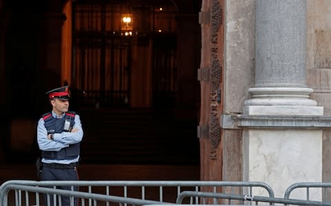 A Mossos d'Esquadra, a Catalan regional police officer, stands guard outside the Generalitat Palace, the Catalan regional government headquarter in Barcelona - Credit: YVES HERMAN/ REUTERS