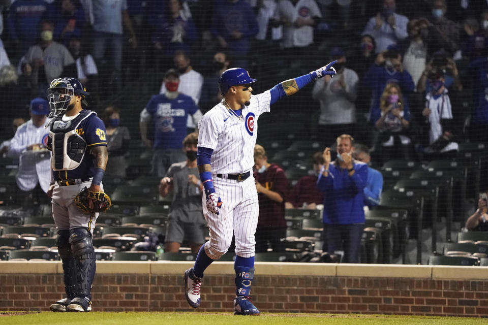 Chicago Cubs' Javier Baez gestures as he crosses home plate after hitting a home run against the Milwaukee Brewers during the fourth inning of a baseball game, Monday, April 5, 2021, in Chicago. (AP Photo/David Banks)