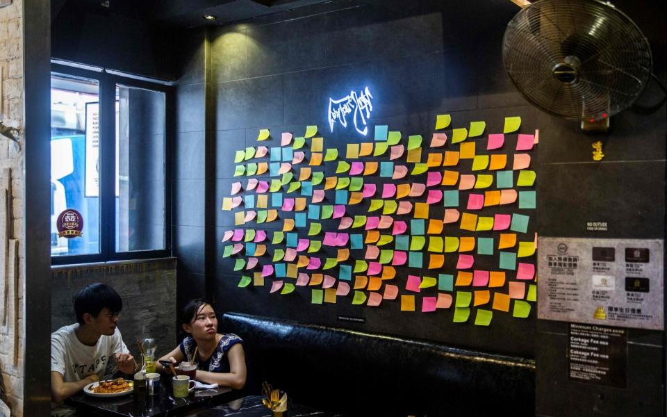 Customers sit near blank notes on a Lennon Wall inside a pro-democracy restaurant in Hong Kong  - AFP