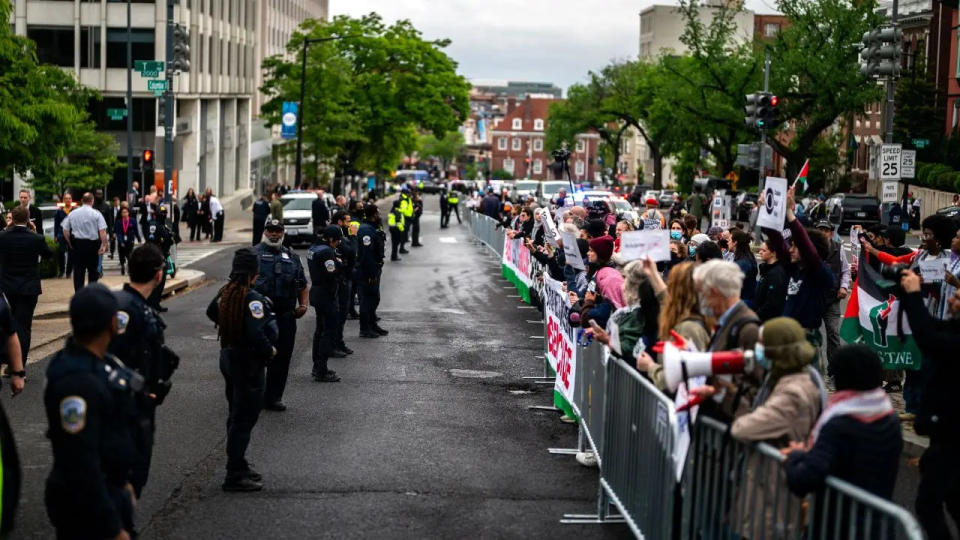 Wide shot of protesters facing police