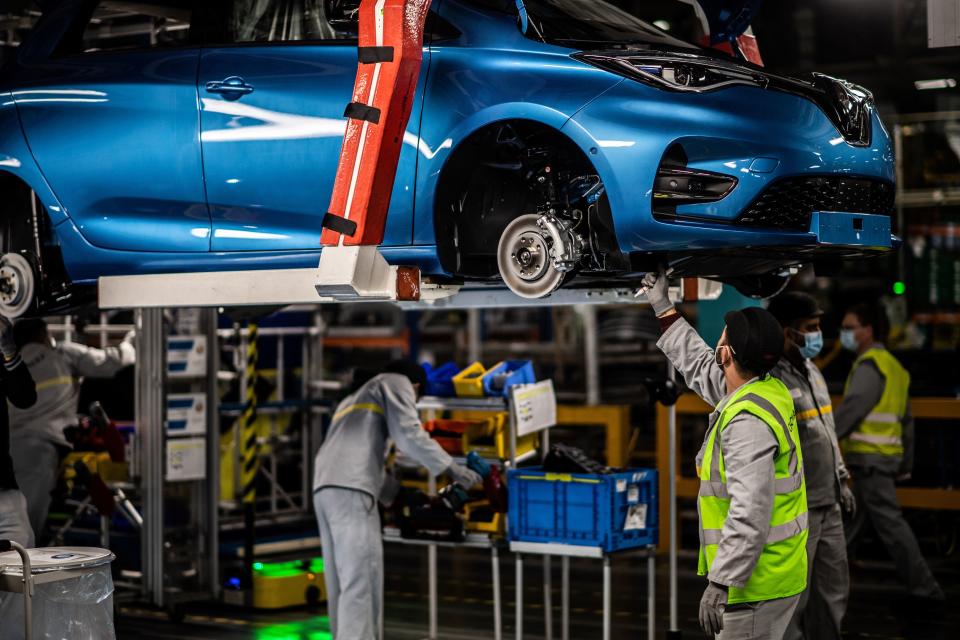 Employees wearing protective masks against the spread of the novel coronavirus, COVID-19, work along the assembly line that produces both the electric vehicle Renault Zoe and the hybrid vehicle Nissan Micra, at Flins-sur-Seine, the largest Renault production site in France on May 6, 2020. - To reopen following the March 17th lockdown across France, the factory has had to enforce all the safety measure required to reduce any spread of COVID-19 at the assembly plant, with workers having to wear protective masks and gloves and diving the assembly line into individual parts to spot any person-to-person contamination. (Photo by Martin BUREAU / AFP) (Photo by MARTIN BUREAU/AFP via Getty Images)