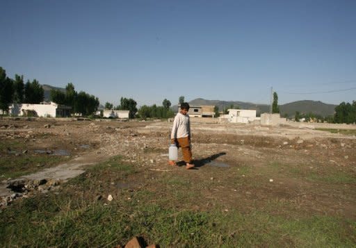 A Pakistani boy carries water cans at the site of the demolished compound of slain Al-Qaeda leader Osama bin Laden in Abbottabad. A Pakistani surgeon recruited by the CIA to help find Osama bin Laden was sentenced to 33 years in prison for treason, officials said