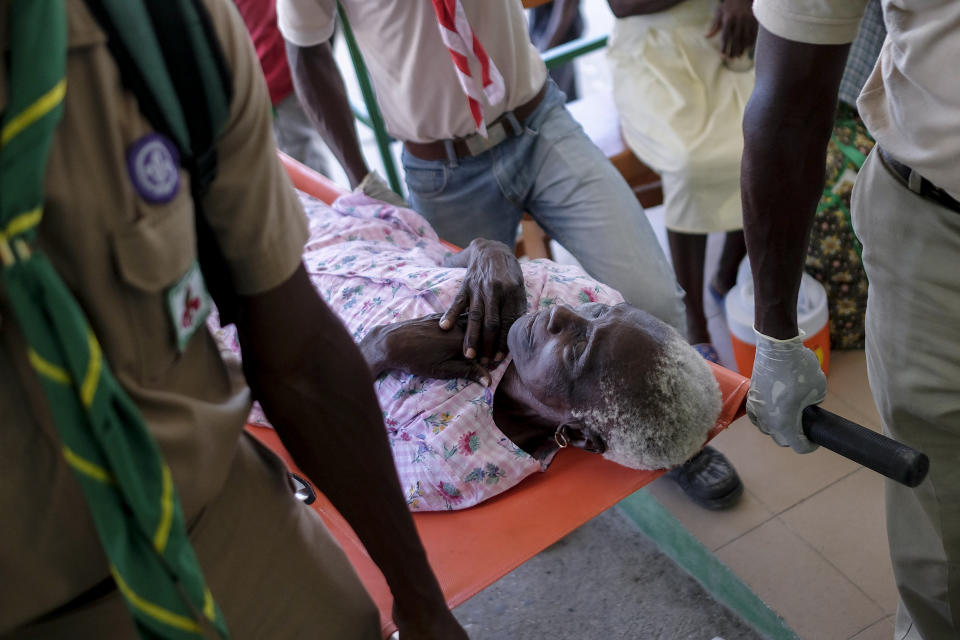 Boy scouts carry on a stretcher, a woman injured in Saturday's 7.2-magnitude earthquake, at the Saint Antoine hospital in Jeremie, Haiti, Wednesday, Aug. 18, 2021. (AP Photo/Matias Delacroix)