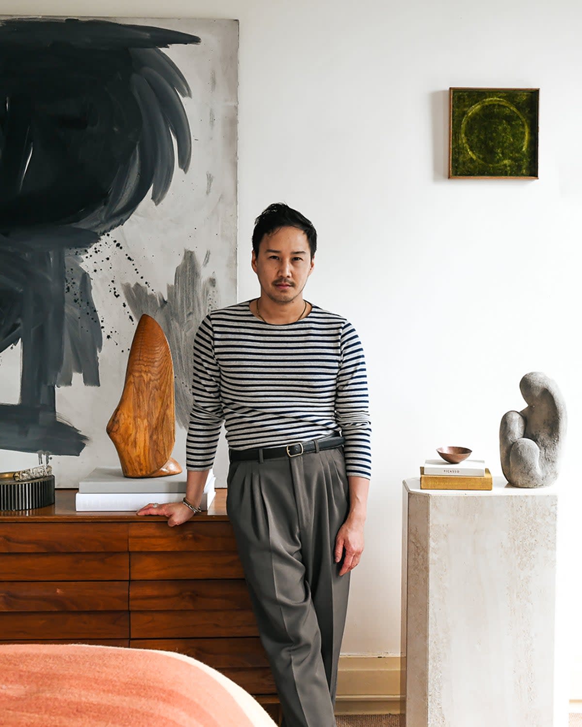 Man leaning on dresser in bedroom