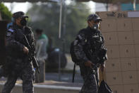 Police officers guard legislative and local elections, at a polling place in San Salvador, El Salvador, Sunday, Feb. 28, 2021. Sunday's elections in El Salvador are seen as a referendum on whether to break the congressional deadlock that has tied the hands of upstart populist President Nayib Bukele. (AP Photo/Salvador Melendez)