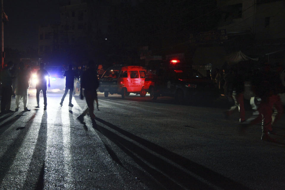 Police officers rush to the incident site following gunmen attack on police headquarters, in Karachi, Pakistan, Friday, Feb. 17, 2023. Gunfire erupted outside of police headquarters in Pakistan's largest city on Friday, as security forces rushed to stave off what appeared to be a bold attack in the heart of Karachi, police and officials said. (AP Photo/Ikram Suri)