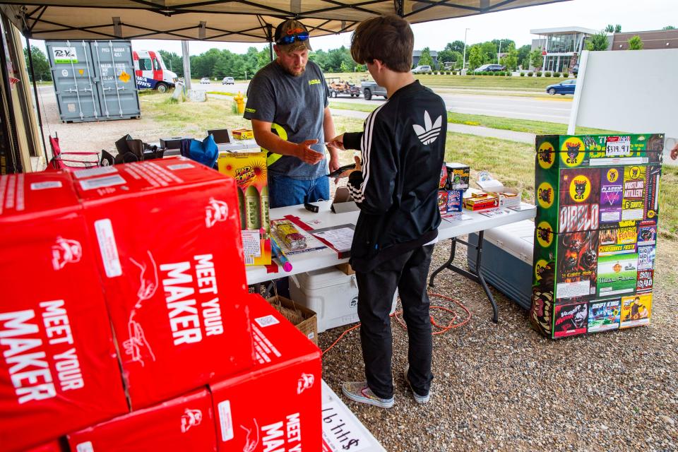 Jacob Enloe buys fireworks from Lucas Allsup at the Iowa Fireworks Company in Clive, Thursday, June 24, 2021. On July 3, 2021, an Iowa Fireworks Company fireworks stand in Clive suffered $10,000 in damages from a fire in a fireworks storage container.