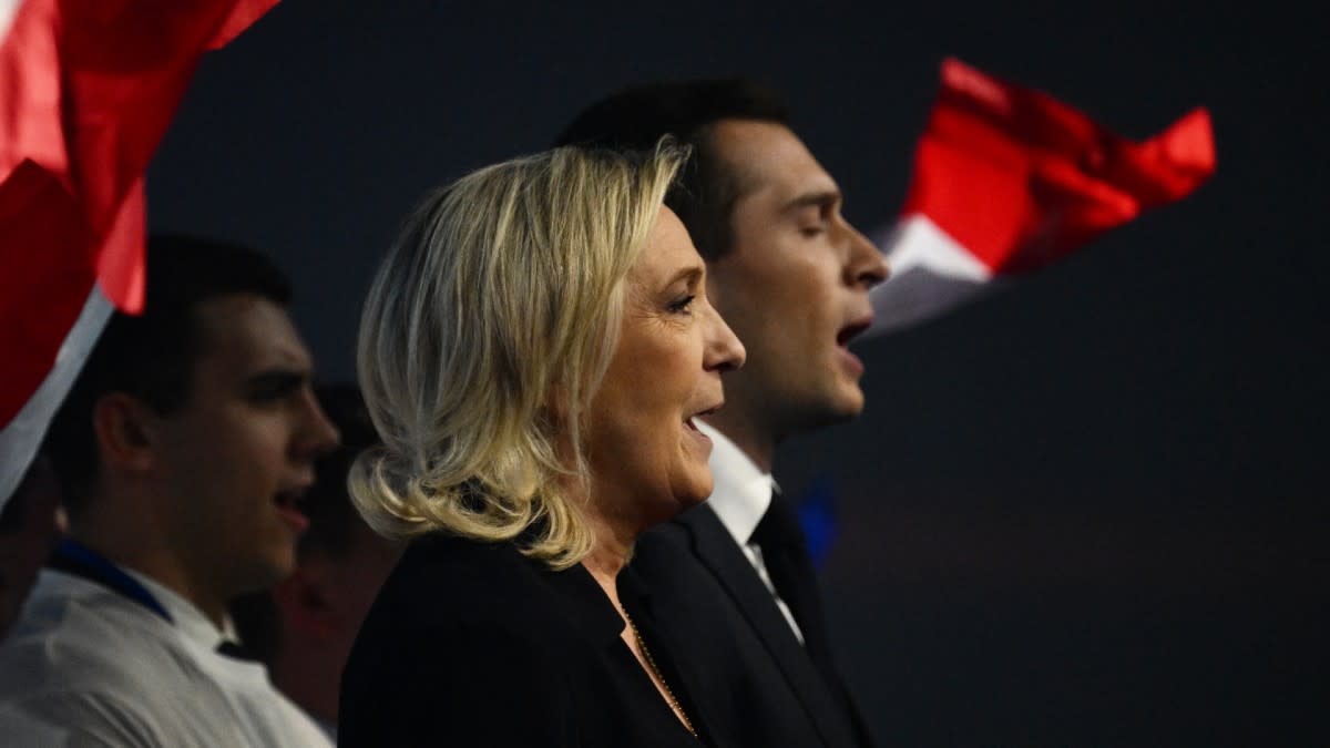 Marine Le Pen et Jordan Bardella chantent l'hymne national lors d'un meeting du Rassemblement national avant les élections européennes, le 3 mars 2024 à Marseille. | Christophe Simon / AFP