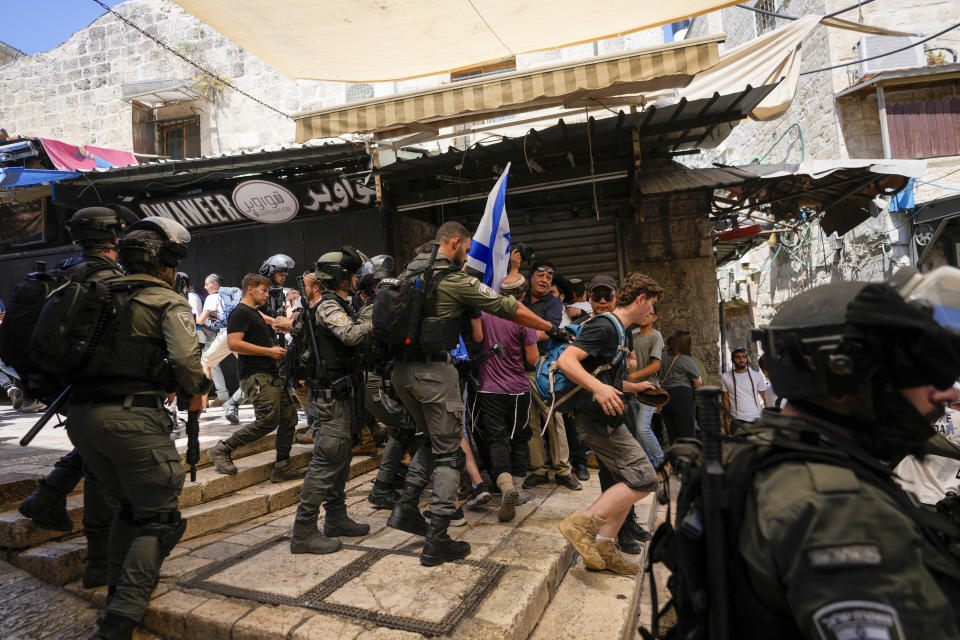 Israeli police officers separate Israelis and Palestinians in a street in the Muslim Quarter of Jerusalem's Old City, shortly before a march through the area by Jewish nationalists in Jerusalem Day, an Israeli holiday celebrating the capture of east Jerusalem in the 1967 Mideast war, Wednesday, June 5, 2024. (AP Photo/Ohad Zwigenberg)