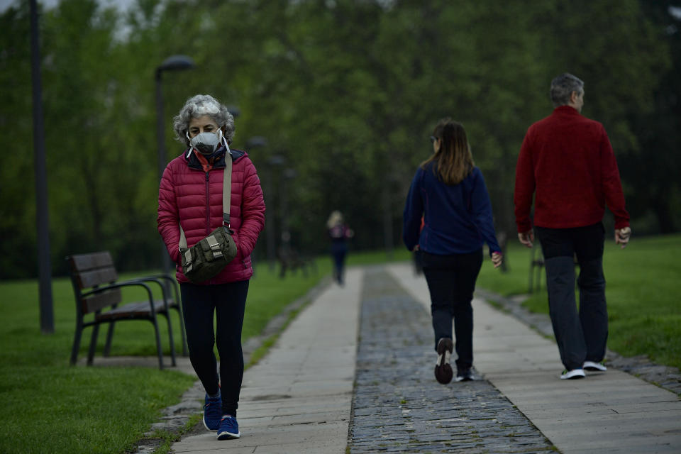 A woman wearing a face mask to protect against coronavirus, goes for a walk along Vuelta del Castillo park, in Pamplona, northern Spain, Saturday, May 2, 2020. Spain relaxed its lockdown measures Saturday, allowing people of all ages to leave their homes for short walks or exercise for the first time since March 14. (AP Photo/Alvaro Barrientos)