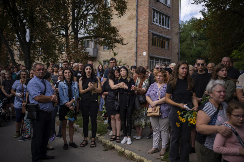 Anastasiia Okhrimenko, awaits the arrival of the coffin with the body of her husband Yurii Stiahliuk, a Ukrainian serviceman who died in combat on Aug. 24 in Maryinka, Donetsk, during his funeral in Bucha, Ukraine, Wednesday, Aug. 31, 2022. (AP Photo/Emilio Morenatti)