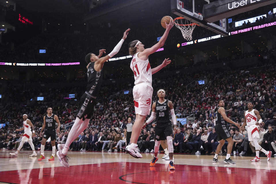 Toronto Raptors' forward Kelly Olynyk (41) scores against San Antonio Spurs' Victor Wembanyama, front left, during second-half NBA basketball game action in Toronto, Monday Feb. 12, 2024. (Chris Young/The Canadian Press via AP)