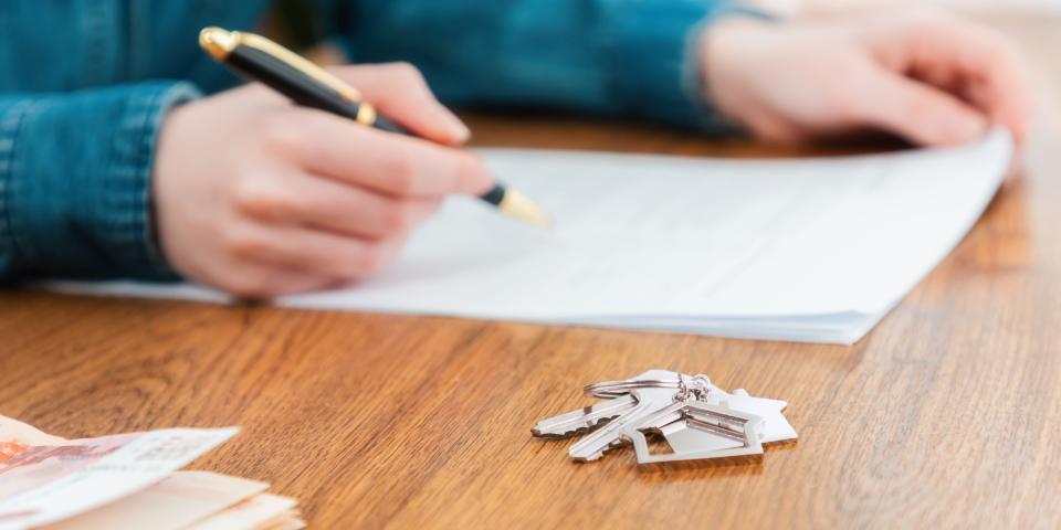 woman signing a contract for the rental or purchase of real estat