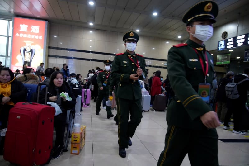 Paramilitary police officers wearing masks are seen at Shanghai railway station in Shanghai