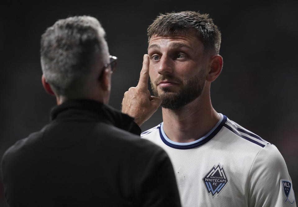 Vancouver Whitecaps' Tristan Blackmon is examined by a doctor after colliding with Austin FC's Jhohan Romana during the first half of an MLS soccer match Saturday, Oct. 1, 2022, in Vancouver, British Columbia. (Darryl Dyck/The Canadian Press via AP)