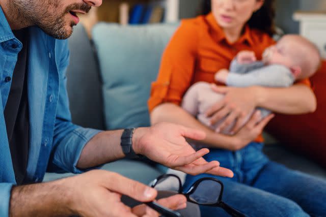 <p>Getty</p> couple fighting while wife holds baby