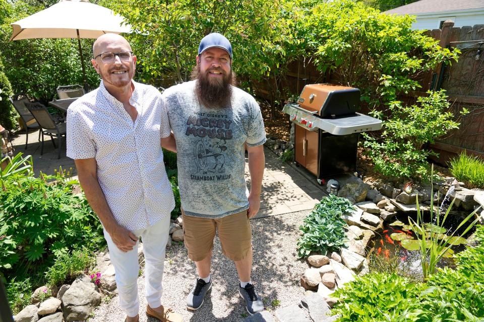 Paul Berens, left, and his partner T.J. Kester stand in their backyard garden at their home in South Milwaukee.