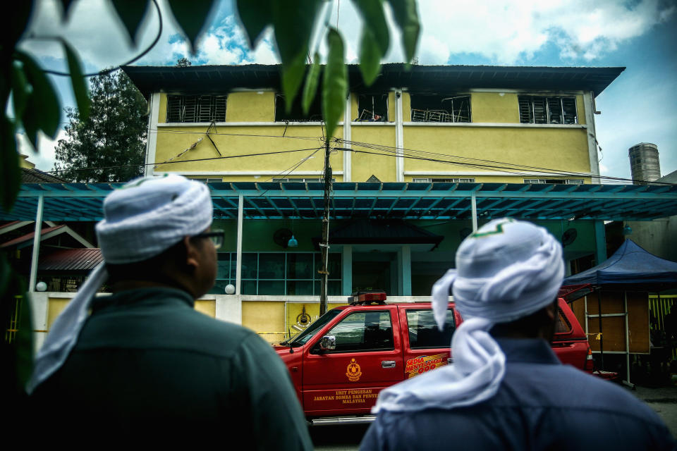 <p>Malaysian Muslims look at the view of religious school Darul Quran Ittifaqiyah after a fire broke out on Sept. 14, 2017 in Kuala Lumpur, Malaysia. (Photo: Mohd Samsul Mohd Said/Getty Images) </p>