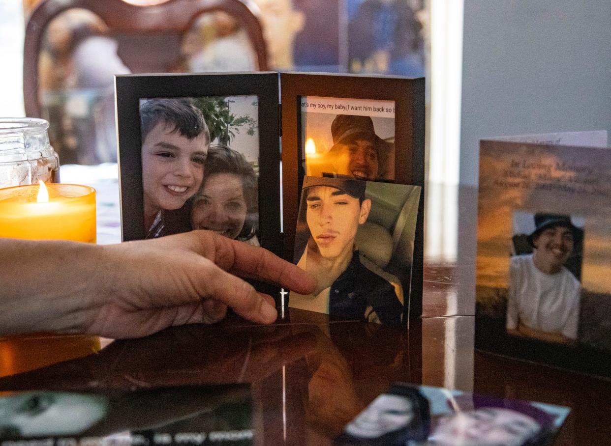 Kathy Nigro points to photos from over the years of her son, Michael Vasquez, displayed in her home. He died in a county jail in May 2022.