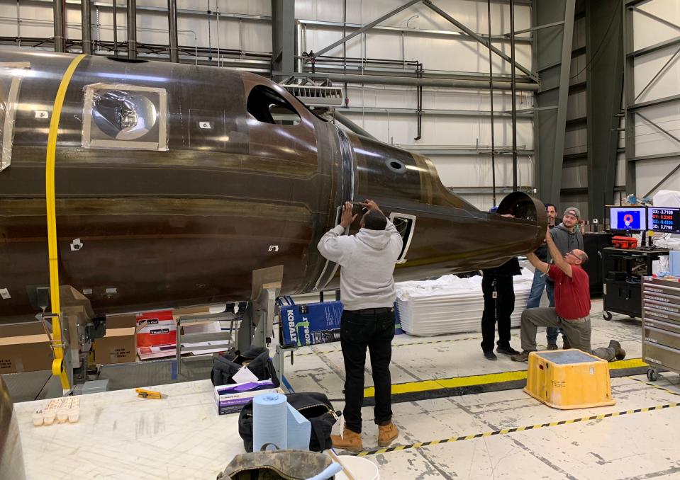 Virgin Galactic engineers work on one of two more SpaceShipTwo crafts that are in progress at the company's headquarters in Mojave, California. Eventually, the company hopes to have as many as six spaceships, which could theoretically allow for multiple flights a week into space.