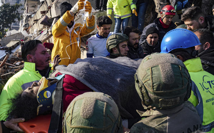 Turkish army commandos and medics rescue a woman from a collapsed building in Hatay, southern Turkey, Wednesday, Feb. 8, 2023. Freezing cold temperatures are hindering rescue teams as they work to save people still trapped in the rubble after a 7.8-magnitude earthquake ripped through the region in the early morning hours Monday. Officials expect the number of reported deaths to increase significantly as operations continue. (Cemal Yurttas/DIA via AP)