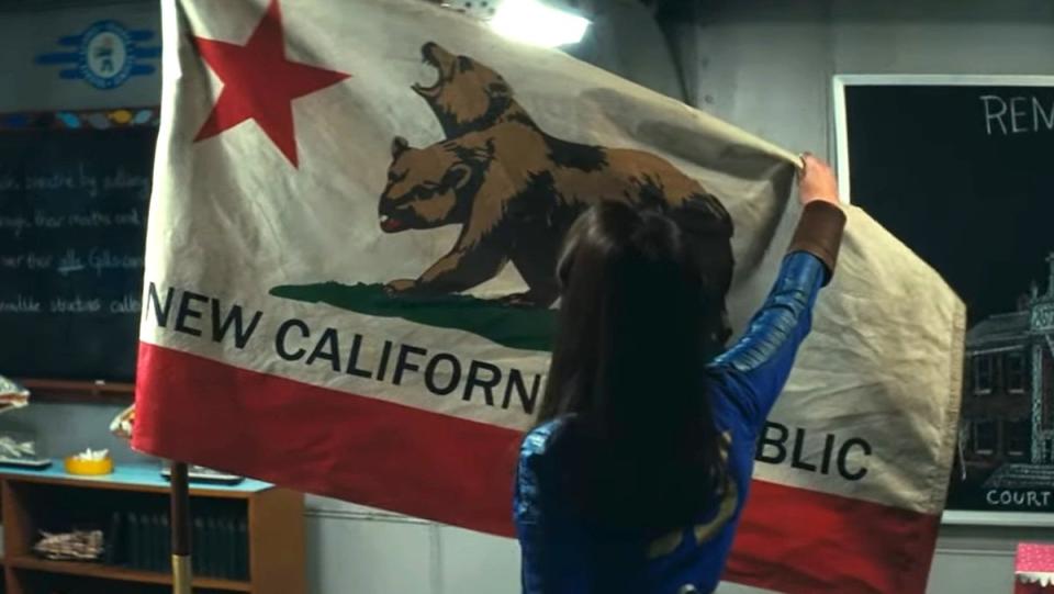 Lucy holds up an NCR flag in Fallout