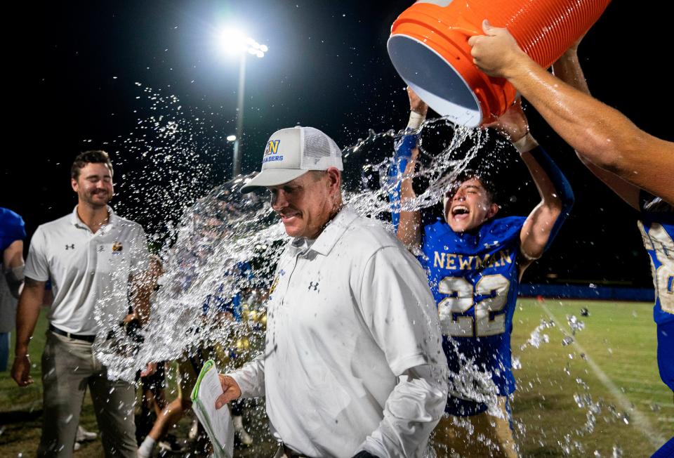 Cardinal Newman coach Jack Daniels gets doused by Cole Dillon (22) and Brady Shea (68) after beating St. Andrew's 41-6 in the 3A regional playoff game in West Palm Beach on Nov. 12, 2021. It wais coach Daniels' first playoff win as the head coach of Cardinal Newman.