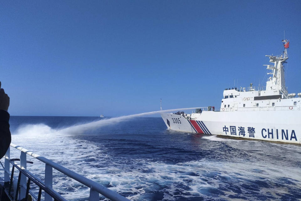 In this photo provided by the Philippine Coast Guard, a Chinese Coast Guard ship, right, uses its water cannons on a Philippine Bureau of Fisheries and Aquatic Resources (BFAR) vessel as it approaches Scarborough Shoal in the disputed South China Sea on Saturday Dec. 9, 2023. The Philippines and its treaty ally, the United States, separately condemned a high-seas assault Saturday by the Chinese coast guard and suspected militia ships that repeatedly blasted water cannons to block three Philippine fisheries vessels from a disputed shoal in the South China Sea. (Philippine Coast Guard via AP)