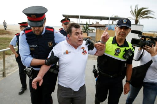 A man is escorted by police after he tried to interrupt a protest in support of jailed Catalan separatist leaders as tensions rise in the region over opposing views on secession from Spain