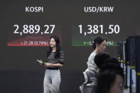 Currency traders work near the screen showing the Korea Composite Stock Price Index (KOSPI), left, and the foreign exchange rate between U.S. dollar and South Korean won at the foreign exchange dealing room of the KEB Hana Bank headquarters in Seoul, South Korea, Thursday, July 11, 2024. (AP Photo/Ahn Young-joon)