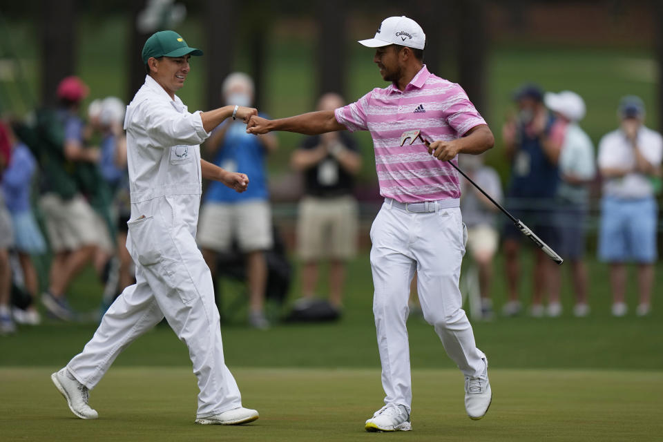 Xander Schauffele is congratulated by his caddie Austin Kaiser after an eagle on the 15th hole during the third round of the Masters golf tournament on Saturday, April 10, 2021, in Augusta, Ga. (AP Photo/Matt Slocum)