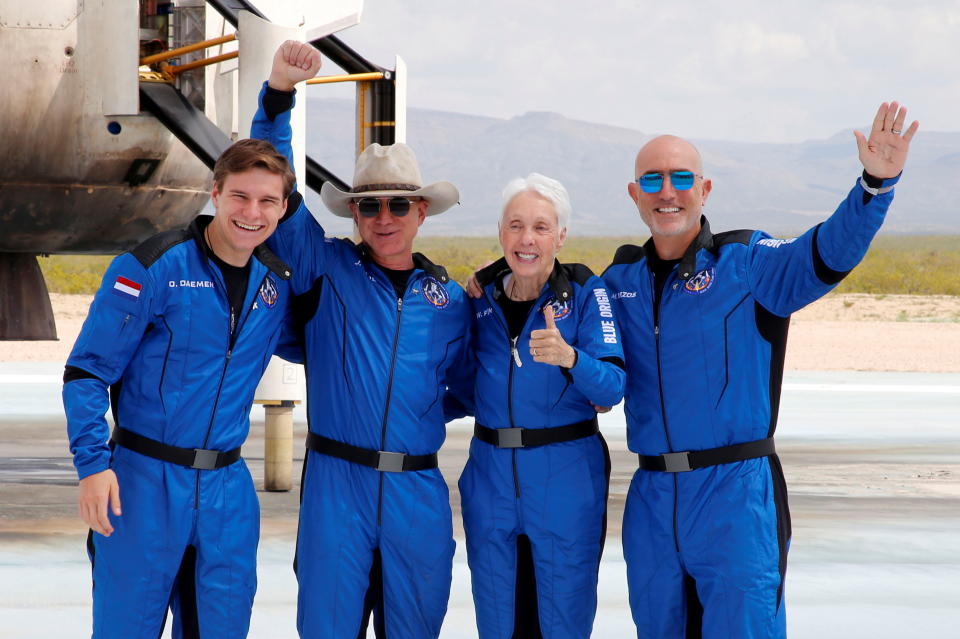 Billionaire American businessman Jeff Bezos (2nd-L) poses for pictures with crew mates, from left, Oliver Damen, 18, Bezos, Wally Funk, 82, and Mark Bezos at the landing pad after they flew on Blue Origin's inaugural flight to the edge of space, in the nearby town of Van Horn, Texas, U.S. July 20, 2021.   REUTERS/Joe Skipper