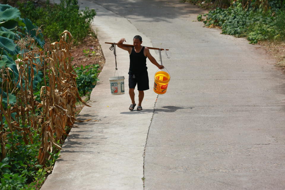 Una persona lleva agua en Suining, Sichuan/ CFOTO/Future Publishing via Getty Images)