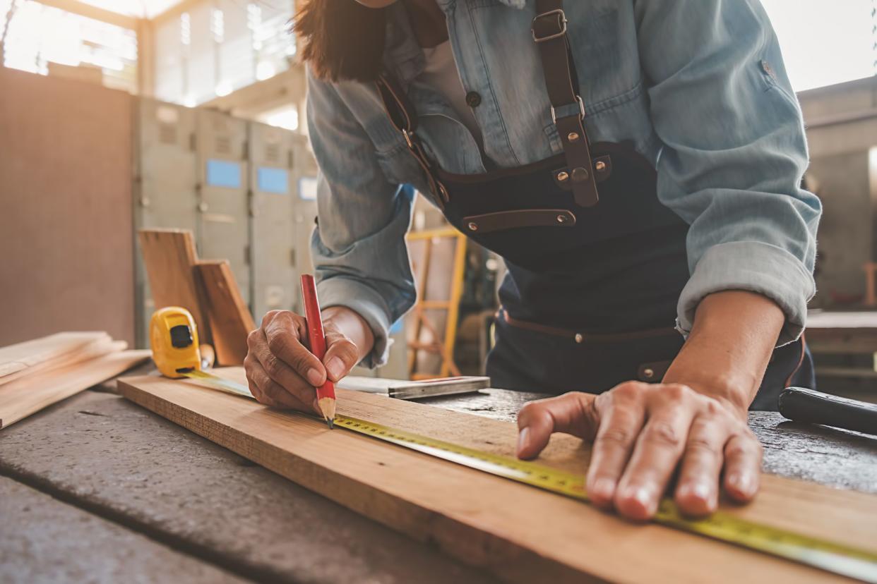 Carpenter working with equipment on wooden table in carpentry shop. woman works in a carpentry shop.