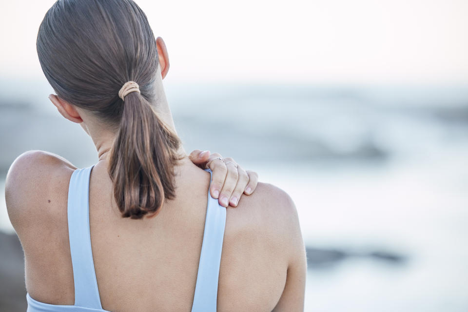 A woman rubbing her shoulder