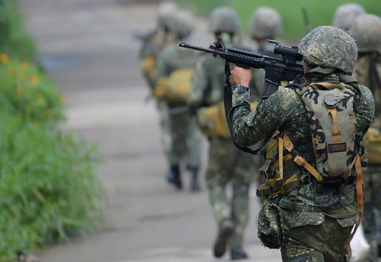 A Philippine Marine aims his assault rifle as he and other Marines advance toward militant positions in Marawi on the southern island of Mindanao