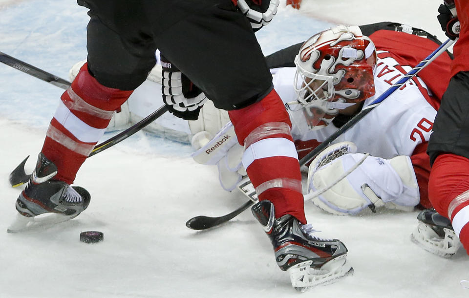 Austria goaltender Bernhard Starkbaum drops to the ice to smother a rebound against Finland in the first period of a men's ice hockey game at the 2014 Winter Olympics, Thursday, Feb. 13, 2014, in Sochi, Russia. (AP Photo/Mark Humphrey)