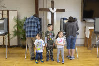 From let, Matthew Reeder, Thomas Reeder and Ruth Reeder wait for their parents Keith Reeder and Chani Reeder to cast their ballots in Idaho's Primary Election, Tuesday, May 17, 2022, in Emmett, Idaho. (AP Photo/Kyle Green)