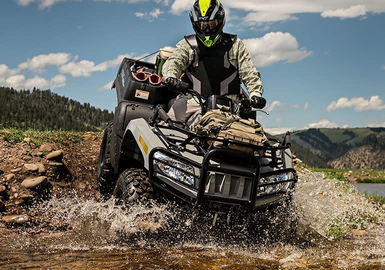 Man riding ATV into a river