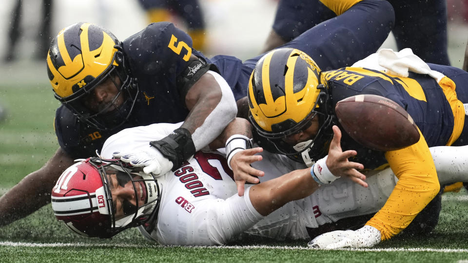 Indiana quarterback Tayven Jackson (2) reaches for the fumbled ball after being hit by Michigan linebacker Michael Barrett (23) in the second half of an NCAA college football game in Ann Arbor, Mich., Saturday, Oct. 14, 2023. (AP Photo/Paul Sancya)