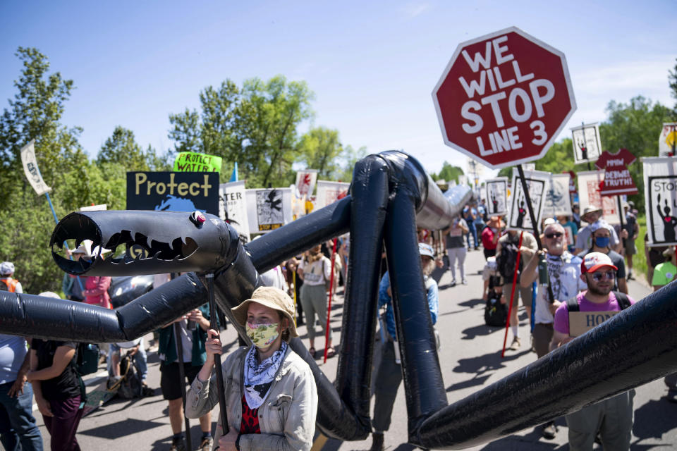 A makeshift "black snake" resembling a pipeline is carried as demonstrators march along Highway 9, on Monday, June 7, 2021, in Clearwater County, Minn. More than 2,000 Indigenous leaders and "water protectors" gathered in Clearwater County from around the country to protest the construction of Enbridge Line 3. The day started with a prayer circle and moved on to a march to the Mississippi headwaters where the oil pipeline is proposed to be built. (Alex Kormann/Star Tribune via AP)