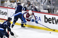 Colorado Avalanche's Mikko Rantanen (96) is tripped by Winnipeg Jets' Neal Pionk (4) during the third period in Game 2 of an NHL hockey Stanley Cup first-round playoff series Tuesday, April 23, 2024, in Winnipeg, Manitoba. (Fred Greenslade/The Canadian Press via AP)