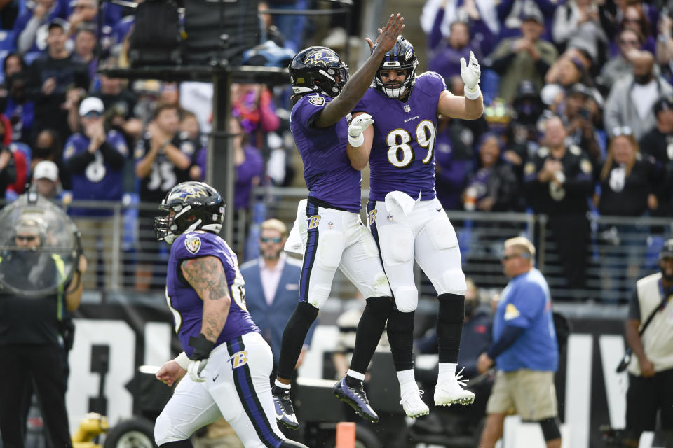 Baltimore Ravens tight end Mark Andrews (89) celebrates with quarterback Lamar Jackson, center, after they connected for a touchdown pass against the Los Angeles Chargers during the second half of an NFL football game, Sunday, Oct. 17, 2021, in Baltimore. (AP Photo/Gail Burton)