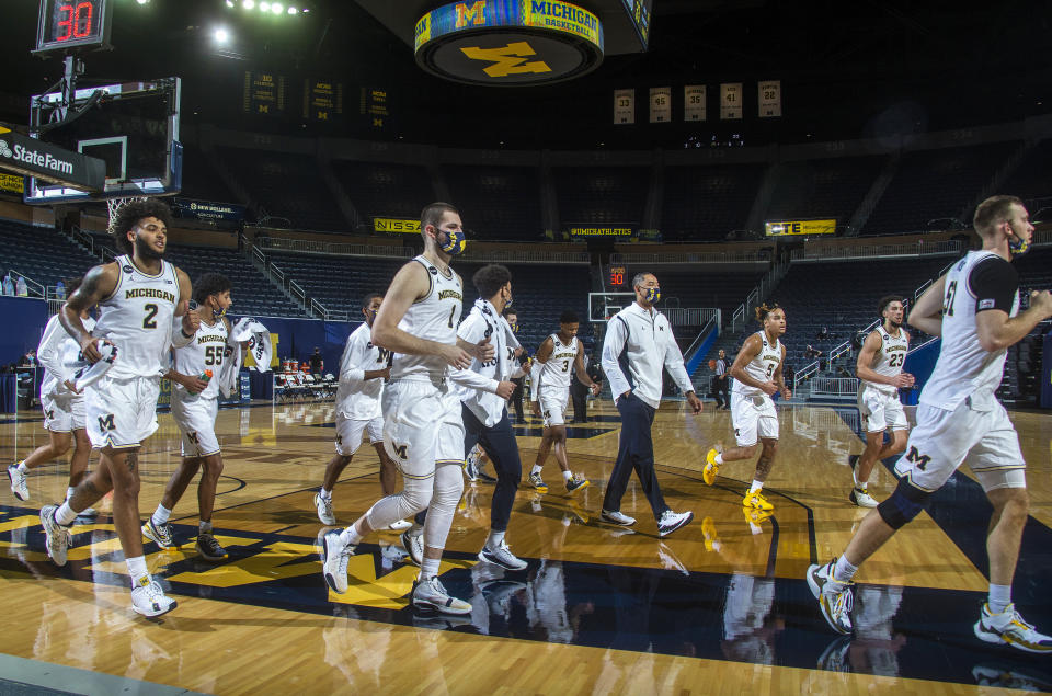 FILE - In this Nov. 29, 2020, file photo, Michigan head coach Juwan Howard, center right, walks off the court with his team at halftime of an NCAA college basketball game against Oakland at Crisler Center in Ann Arbor, Mich. Third-ranked Michigan finally returns to the court this weekend for the first time in over three weeks, and the Big Ten leaders will hope their virus-induced layoff hasn't knocked them out of the impressive groove the Wolverines were in. (AP Photo/Tony Ding, File)