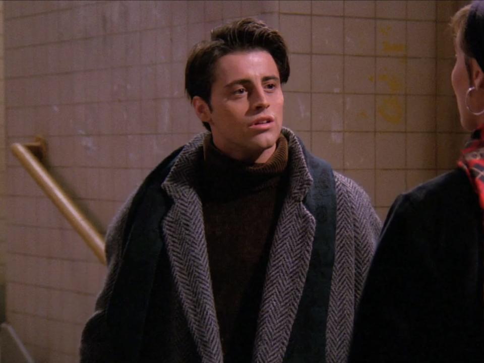 joey tribbiani wearing a sweater, tweed peacoat, and green scarf