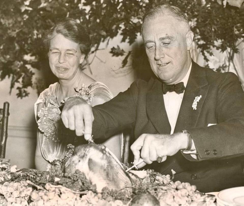 First Lady Eleanor Roosevelt watches as President Franklin D. Roosevelt carves the turkey at the annual Thanksgiving feast at Warm Springs, Ga., on Nov. 29, 1935.