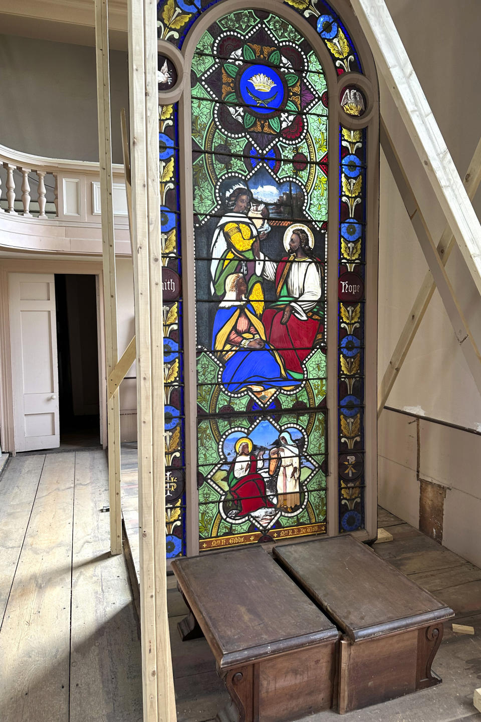 A nearly 150-year-old stained-glass window is displayed Monday, May 1, 2023 inside the now-closed St. Mark's Episcopal church, in Warren, R.I. The nearly 150-year-old stained-glass window from the Rhode Island church that depicts Christ and three New Testament women with dark skin has stirred up questions about race and the place of women in both biblical and 19th century society. (AP Photo/Mark Pratt)